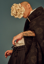 큼직한 꽃무늬를 은은하게 새긴 검은색 케이프 코트·흰색 셔츠·줄무늬 캐럿 팬츠 모두 가격미정 에르메네질도 제냐 꾸뛰르 컬렉션 by 스테파노 필라티, 굵직한 팔찌 가격미정 프라다 제품.