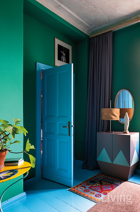 벽면은 초록색, 바닥은 하늘색으로 입힌 침실. 사이드보드는 마르틴 홀자펠이 디자인한 가구이며, 노란색 테이블은 빈티지 제품이다.  